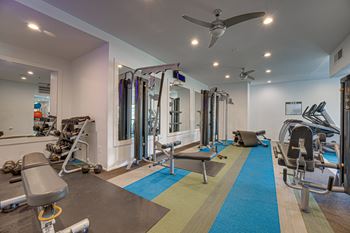 A gym with a variety of equipment including weights and machines.